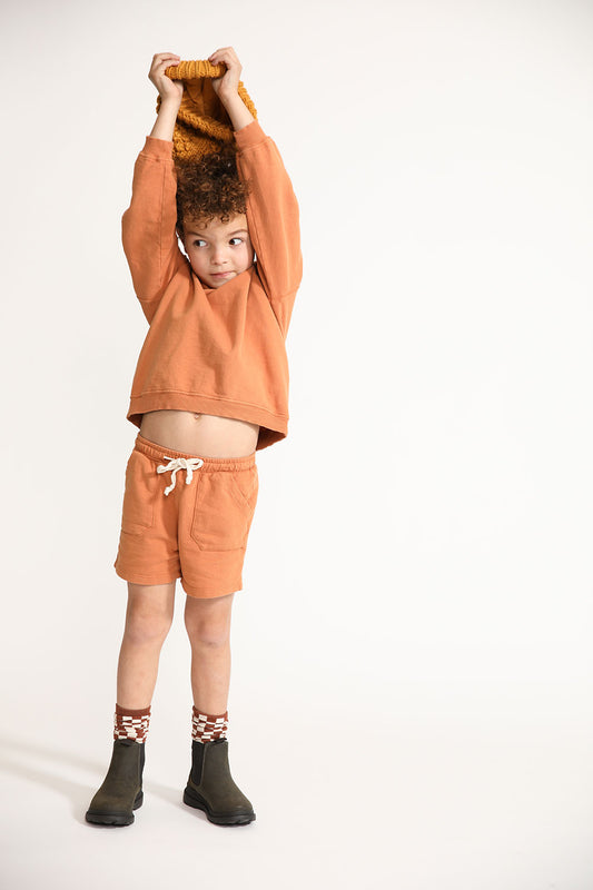 Young boy wearing Everyway kids activewear. Featuring Core Sweat Shorts in Meerkat.