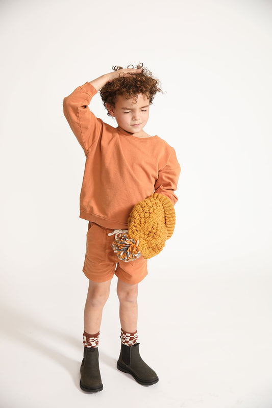 Young boy wearing Everyway kids activewear. Featuring Core Sweat Shorts in Meerkat.
