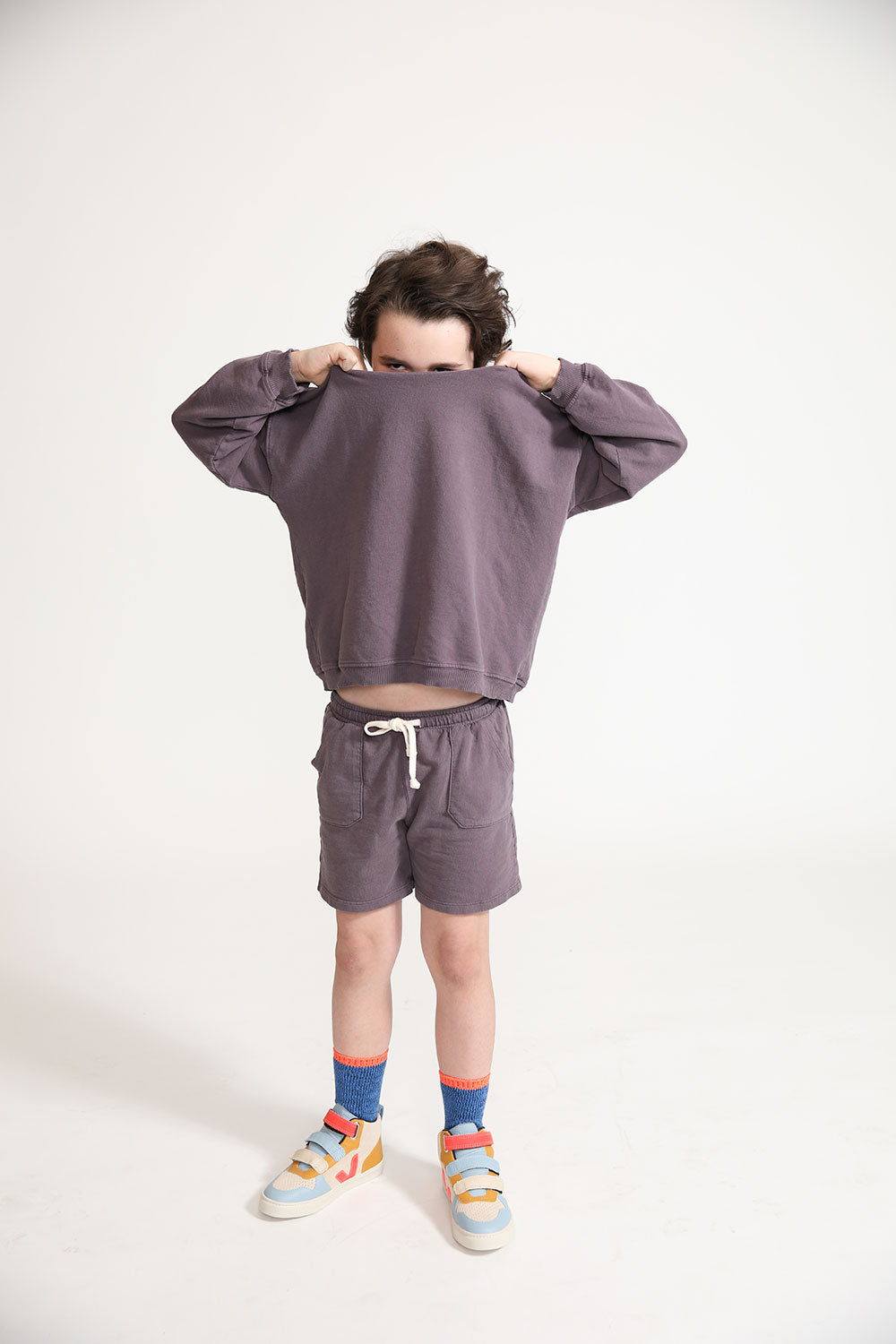 Young boy wearing Everyway kids activewear. Featuring Core Sweat Shorts in Plum.