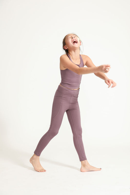 Young girl wearing Everyway kids activewear. Featuring Plum Longline Crop and All Day Leggings.