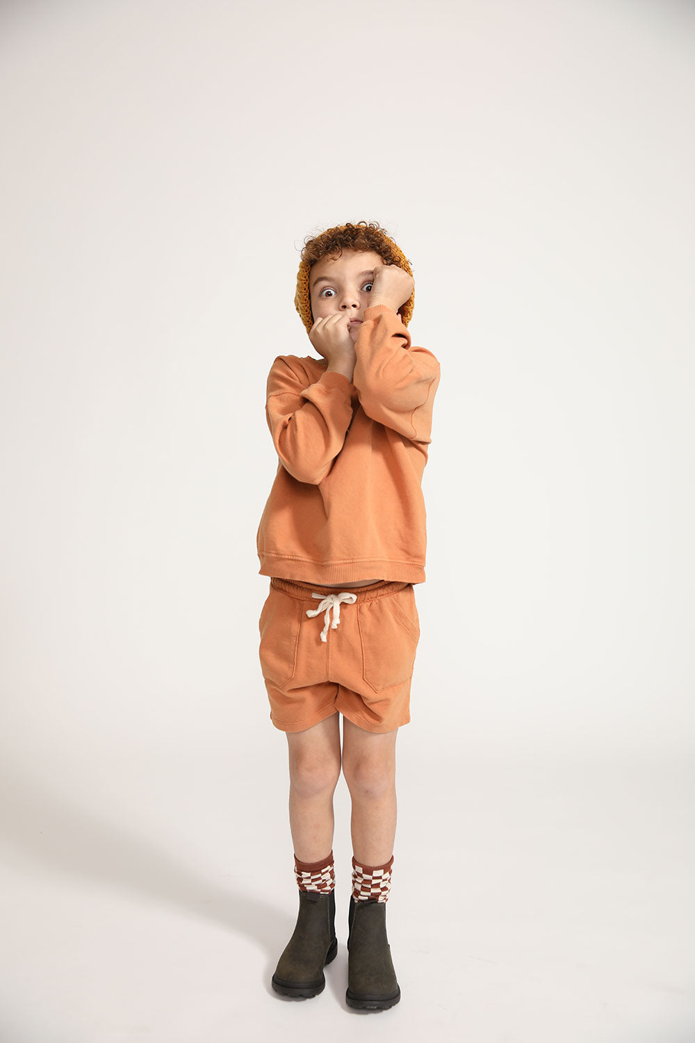 Young boy wearing Everyway kids activewear. Featuring Core Sweat Shorts in Meerkat.