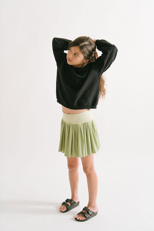 Young girl wearing Everyway kids activewear. Featuring Pleated Court Skort in Lime.