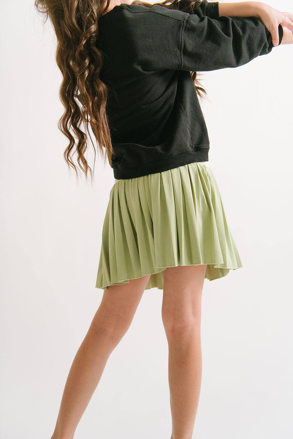 Young girl wearing Everyway kids activewear. Featuring Pleated Court Skort in Lime.
