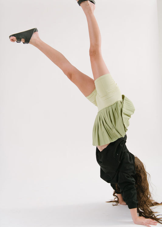 Young girl wearing Everyway kids activewear. Featuring Pleated Court Skort in Lime.