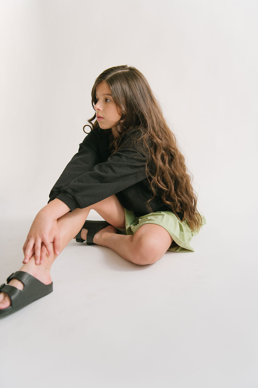 Young girl wearing Everyway kids activewear. Featuring Pleated Court Skort in Lime.
