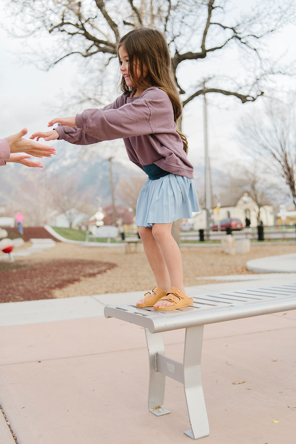 Young girl wearing Everyway kids activewear. Featuring Pleated Court Skort in Ocean.