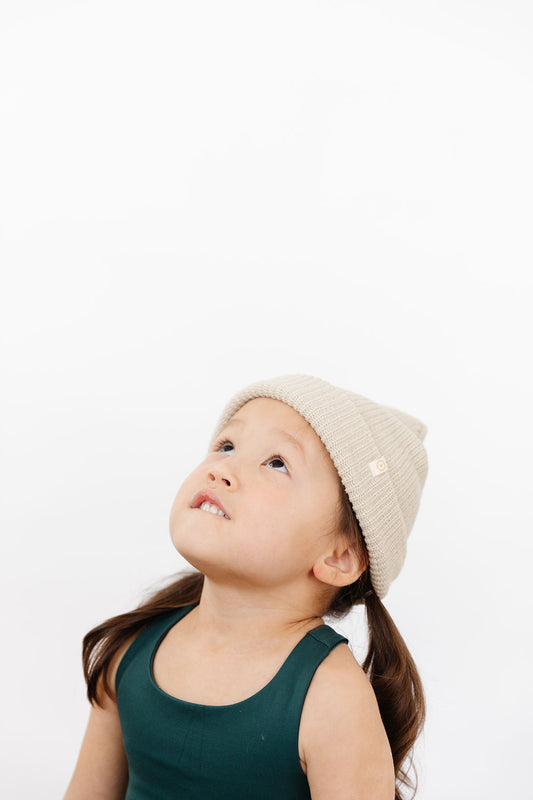 Young girl wearing Everyway kids activewear. Featuring Waffle Knit Beanie in Cream.