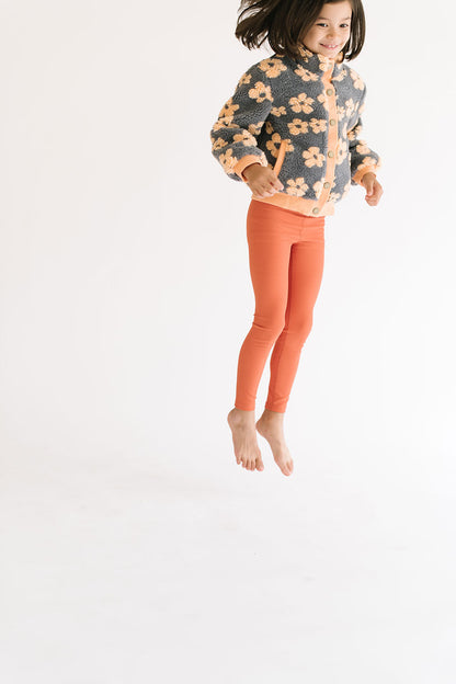 Young girl wearing Everyway kids activewear. Featuring Flower Power Jacket in Melon.