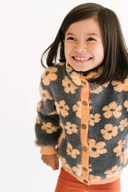 Young girl wearing Everyway kids activewear. Featuring Flower Power Jacket in Melon.