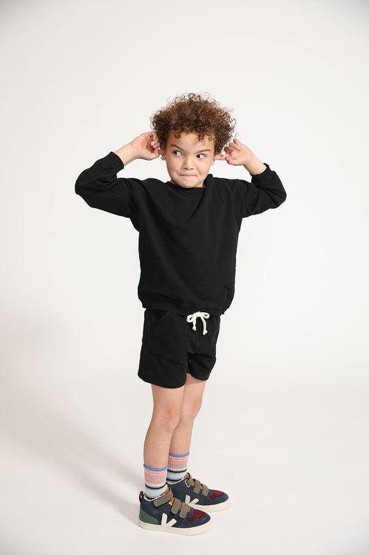 Young boy wearing Everyway kids activewear. Featuring Core Sweat Shorts in Black.