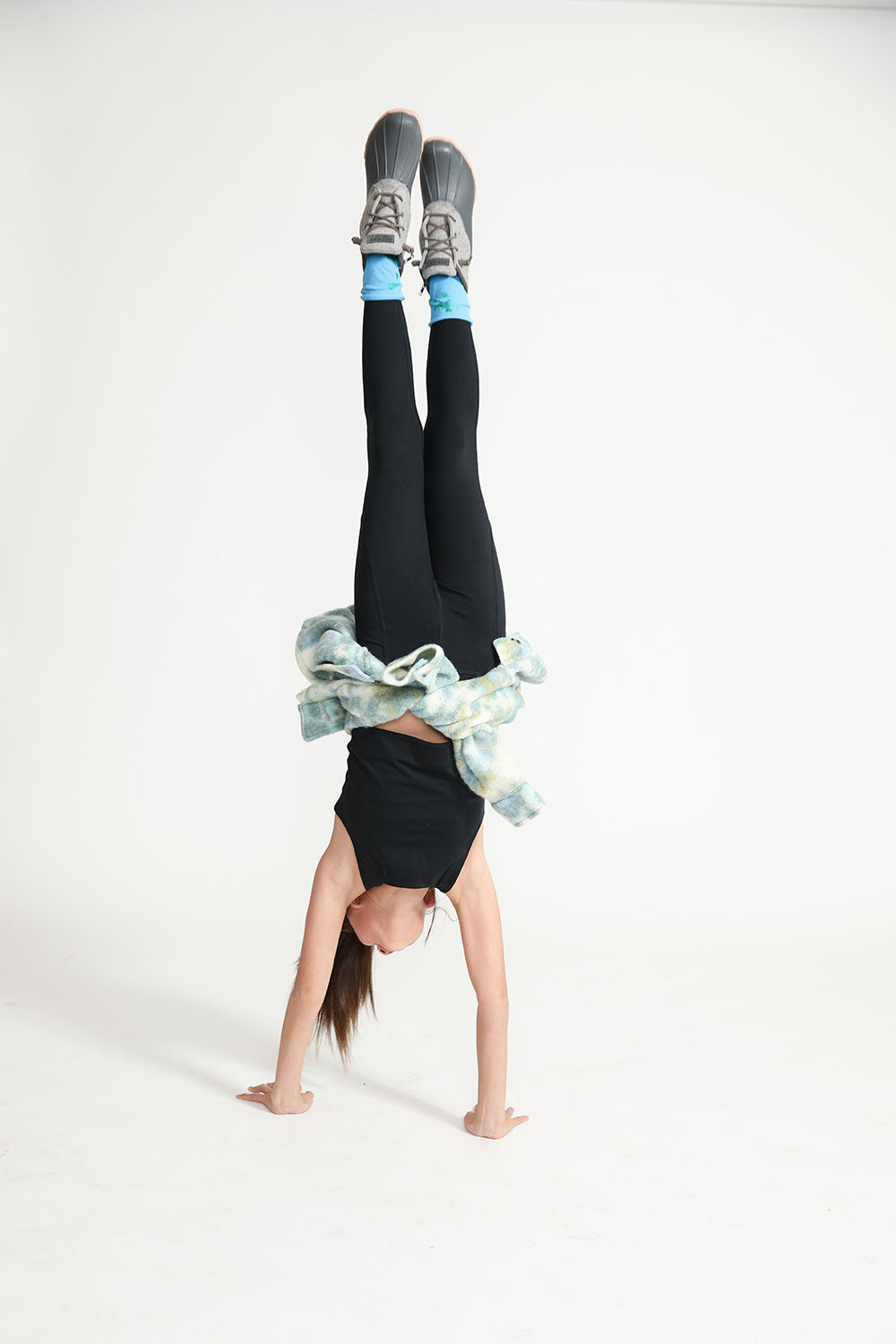 Young girl doing a headstand wearing Everyway kids activewear. Featuring black Longline Crop and All Day Leggings.