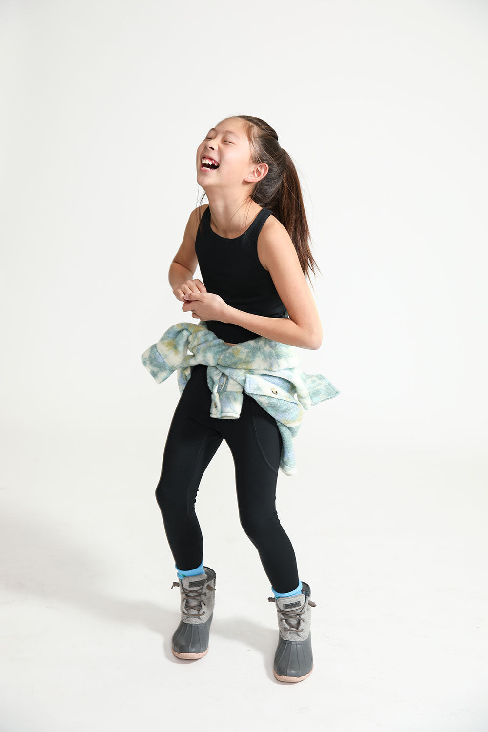 Young girl laughing while wearing Everyway kids activewear. Featuring black Longline Crop and All Day Leggings.
