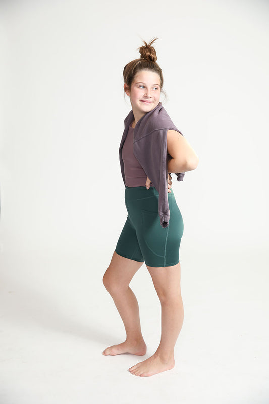 Young girl wearing Everyway kids activewear. Featuring Cycle Shorts in Pine.