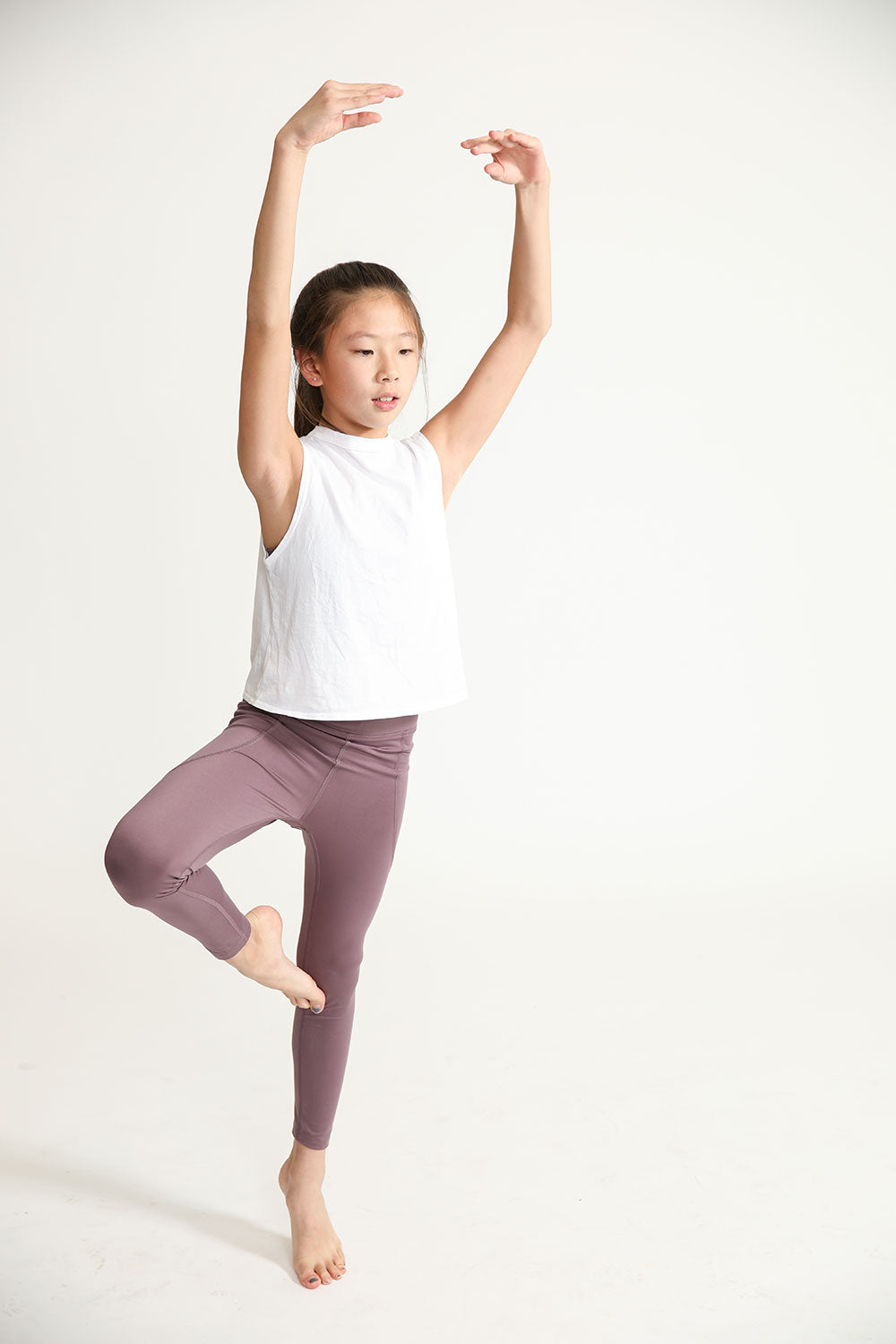 Young girl wearing Everyway kids activewear. Featuring Daily Tank Top in White.