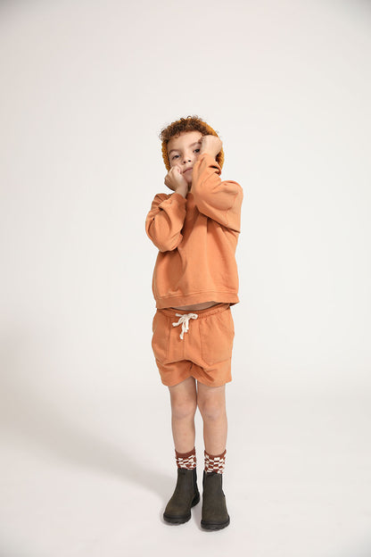 Young boy wearing Everyway kids activewear. Featuring Core Sweat Shirt in Meerkat.