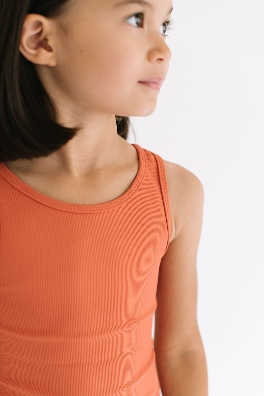 Young girl wearing Everyway kids activewear. Featuring Longline Crop in Persimmon.