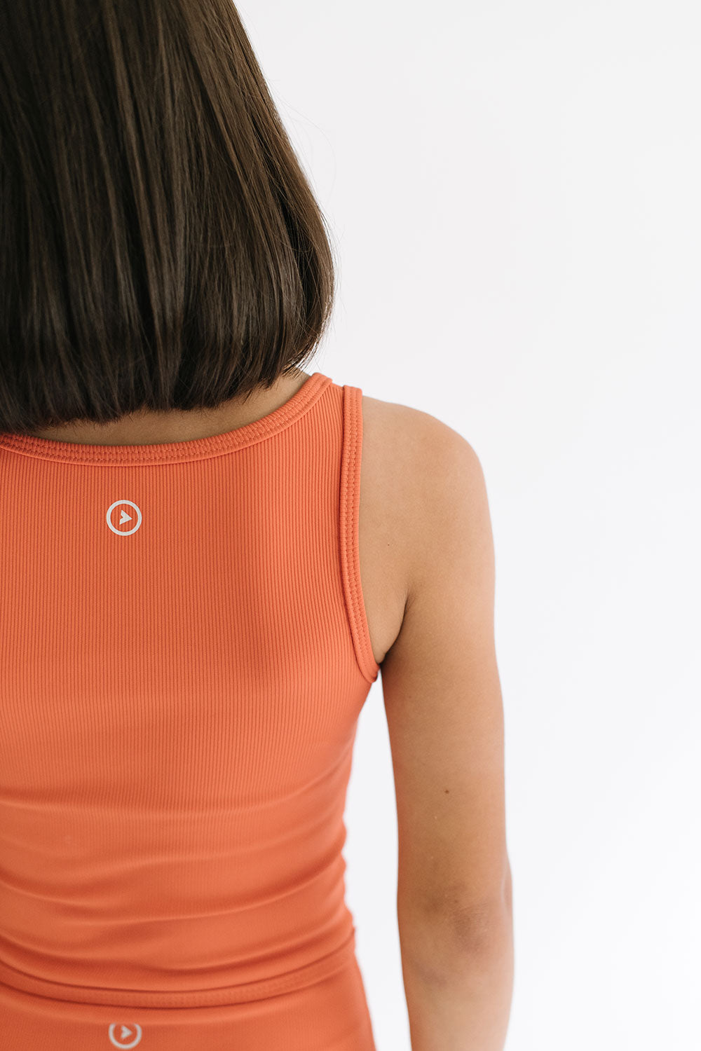 Young girl wearing Everyway kids activewear. Featuring Longline Crop in Persimmon.