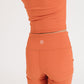 Young girl wearing Everyway kids activewear. Featuring Ribbed Cycle Shorts in Persimmon.