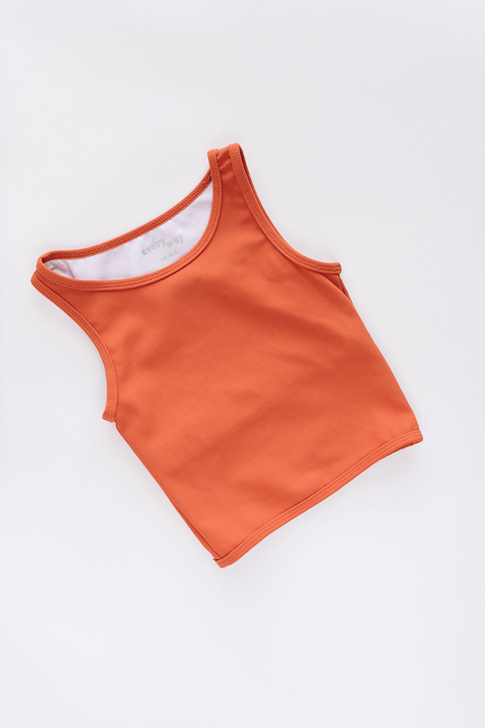 Young girl wearing Everyway kids activewear. Featuring Longline Crop in Persimmon.