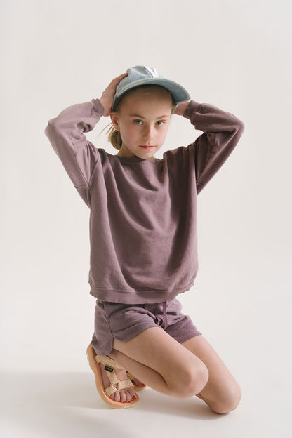 Young girl wearing Everyway kids activewear. Featuring Cloud Shorts in Plum.