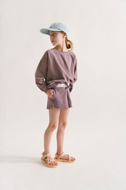 Young girl wearing Everyway kids activewear. Featuring Cloud Shorts in Plum.