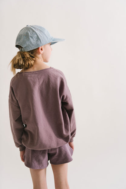 Young girl wearing Everyway kids activewear. Featuring Cloud Shorts in Plum.