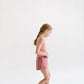 Young girl wearing Everyway kids activewear. Featuring Cloud Shorts in Berry.
