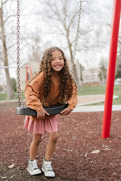 Young girl wearing Everyway kids activewear. Featuring Pleated Court Skort in Rose.