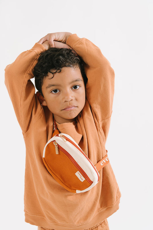 Young boy dressed in Everyway's kids activewear. Featuring fanny pack in rust