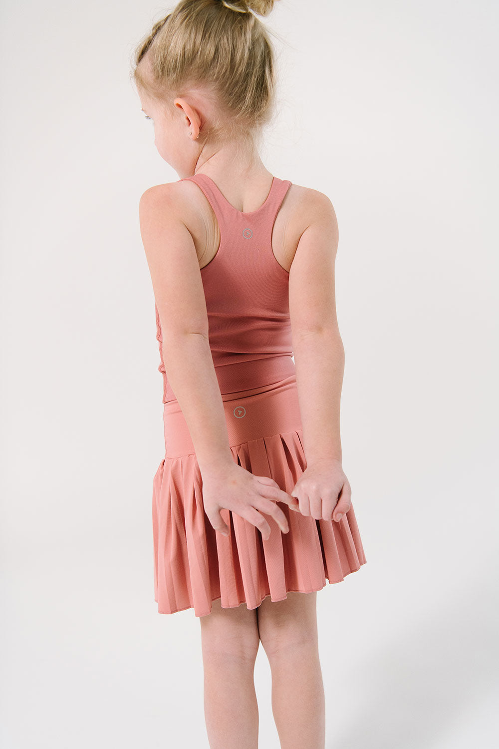 Young girl wearing Everyway kids activewear. Featuring Pleated Court Skort in Rose.