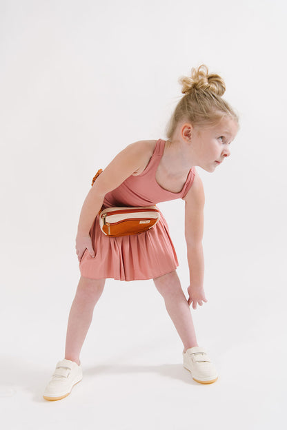 Young girl wearing Everyway kids activewear. Featuring Pleated Court Skort in Rose.